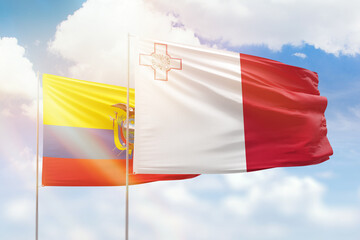 Sunny blue sky and flags of malta and ecuador