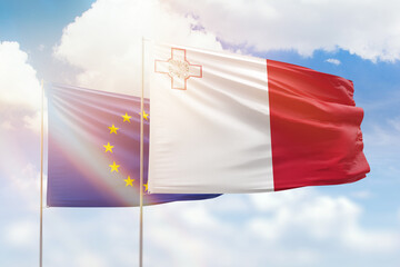 Sunny blue sky and flags of malta and european union