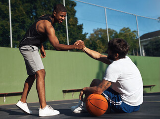 You played so well dude. Shot of two sporty young men shaking hands on a basketball court.