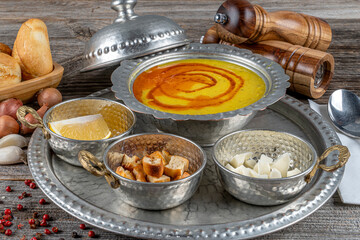 Turkish lentil soup with lemon slice and bread and black pepper beside.