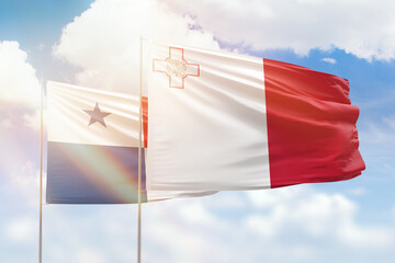 Sunny blue sky and flags of malta and panama