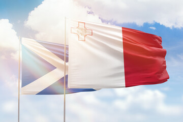 Sunny blue sky and flags of malta and scotland