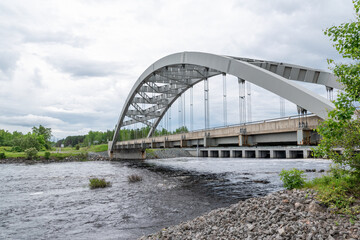 Fototapeta premium A bridge crosses the Montreal River in the small town of Latchford, Ontario on an overcast day.