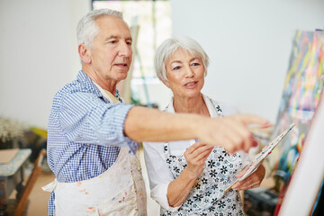 We inspire each other. Shot of a senior couple painting at home.