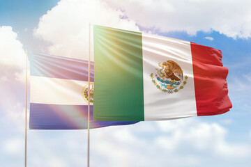 Sunny blue sky and flags of mexico and el salvador
