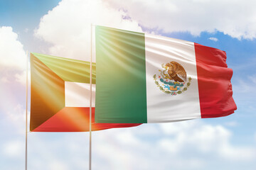 Sunny blue sky and flags of mexico and kuwait