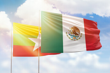 Sunny blue sky and flags of mexico and myanmar