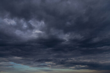 Naklejka na ściany i meble Storm sky with dark grey cumulus clouds and blue sky background texture, thunderstorm