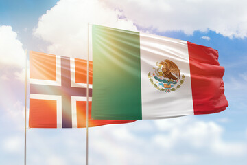 Sunny blue sky and flags of mexico and norway