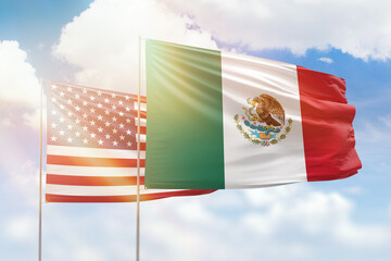 Sunny blue sky and flags of mexico and usa