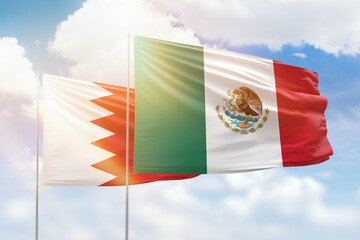 Sunny blue sky and flags of mexico and bahrain