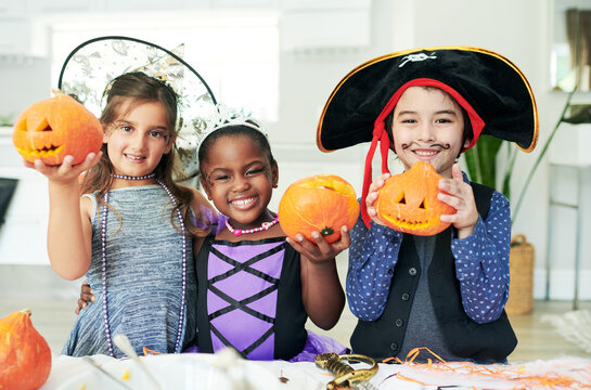 Some pumpkin party fun. Shot of a group of little children showing their carved pumpkins at a party.