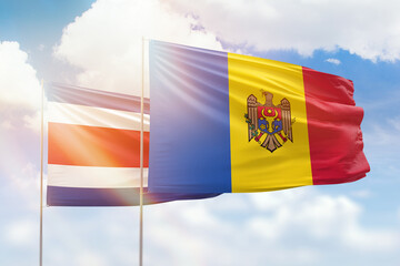 Sunny blue sky and flags of moldova and costa rica