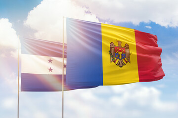 Sunny blue sky and flags of moldova and honduras