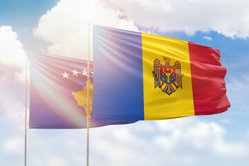 Sunny blue sky and flags of moldova and kosovo