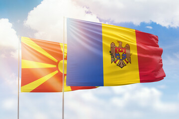 Sunny blue sky and flags of moldova and north macedonia