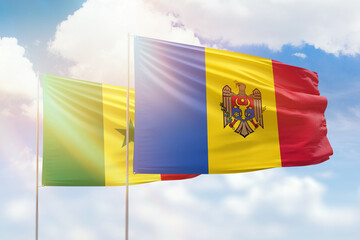 Sunny blue sky and flags of moldova and senegal