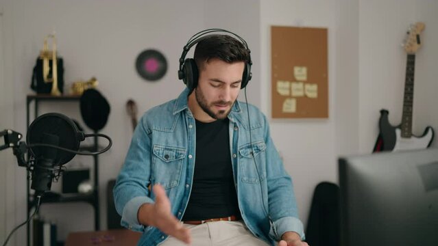 Young hispanic man artist smiling confident having video call at music studio