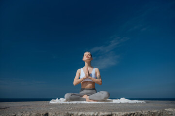 Fototapeta premium Yoga practice and meditation in nature. Woman practicing near Black sea.