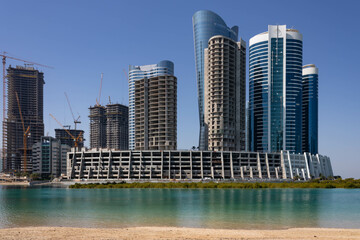 Fototapeta na wymiar Modern high-rise residential and office buildings under construction on Al Reem island in Abu Dhabi, UAE