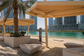 Fototapeta na wymiar Al Reem Central park, beach walk with sun shading and stone benches, Abu Dhabi