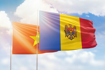 Sunny blue sky and flags of moldova and vietnam