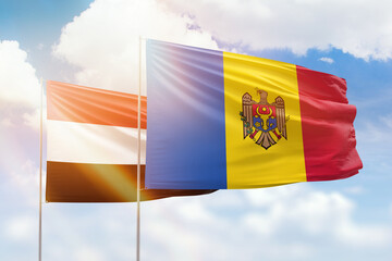 Sunny blue sky and flags of moldova and yemen