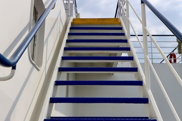 Blue metal stairs and white wall aboard ship