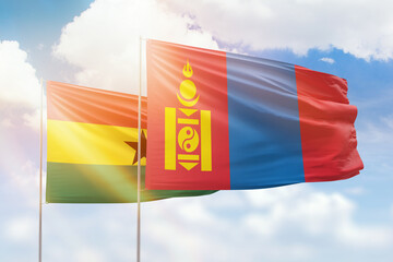 Sunny blue sky and flags of mongolia and ghana