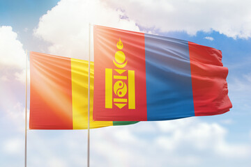 Sunny blue sky and flags of mongolia and guinea