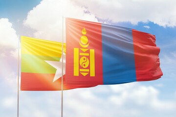 Sunny blue sky and flags of mongolia and myanmar