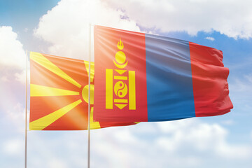 Sunny blue sky and flags of mongolia and north macedonia