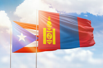 Sunny blue sky and flags of mongolia and puerto rico