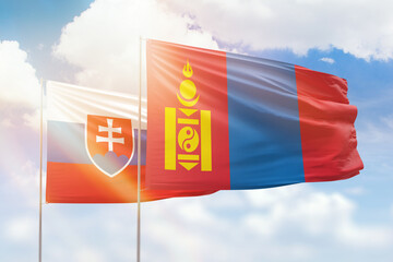 Sunny blue sky and flags of mongolia and slovakia