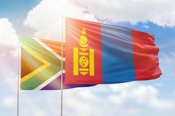 Sunny blue sky and flags of mongolia and south africa