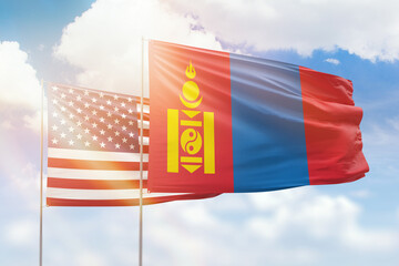 Sunny blue sky and flags of mongolia and usa