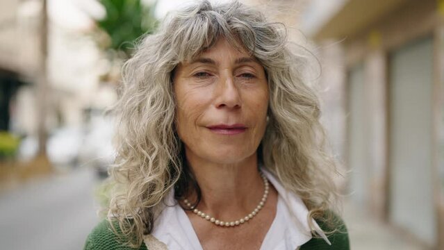 Middle age woman smiling confident standing at street