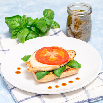 Open face sandwich with chicken, mozzarella, tomato, pesto and basil, square format