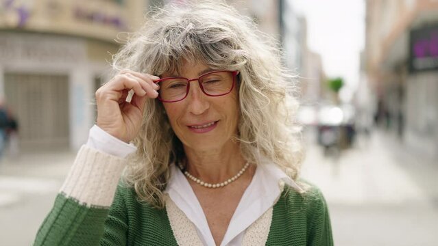 Middle age woman smiling confident standing at street
