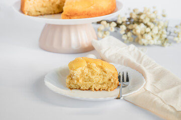 Moist and delicious homemade pineapple cake. Cake being cut. Slice of cake placed on a plate, ready to eat. white background.