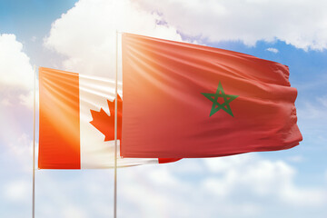 Sunny blue sky and flags of morocco and canada