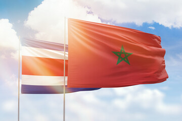 Sunny blue sky and flags of morocco and costa rica