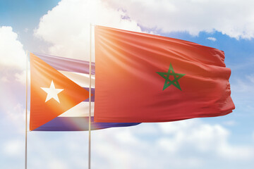 Sunny blue sky and flags of morocco and cuba