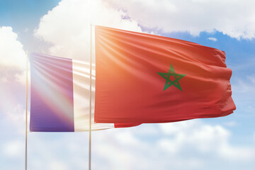 Sunny blue sky and flags of morocco and france