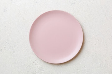 Top view of empty pink plate on cement background. Empty space for your design