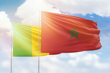 Sunny blue sky and flags of morocco and mali