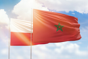 Sunny blue sky and flags of morocco and poland