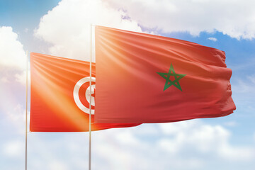 Sunny blue sky and flags of morocco and tunisia