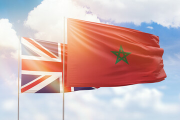 Sunny blue sky and flags of morocco and united kingdom