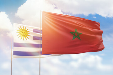 Sunny blue sky and flags of morocco and uruguay